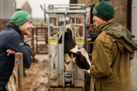 Two Tyndale staff chatting in a milk parlour