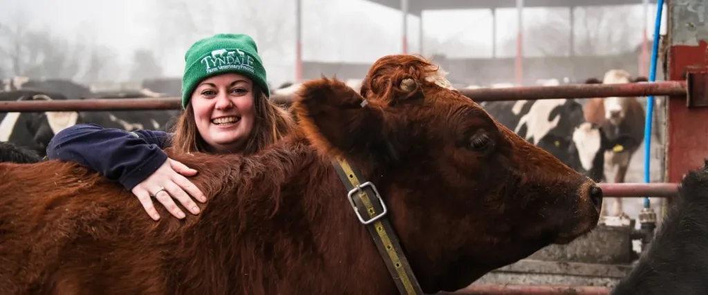 Vet Tech smiling with a cow