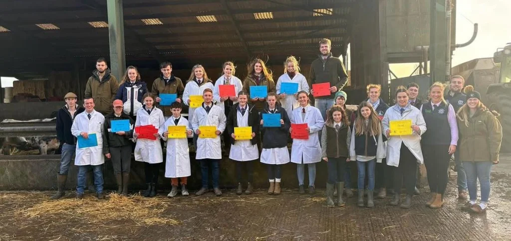 Group shot of Gloucestershire Young Farmers in front of cow shed